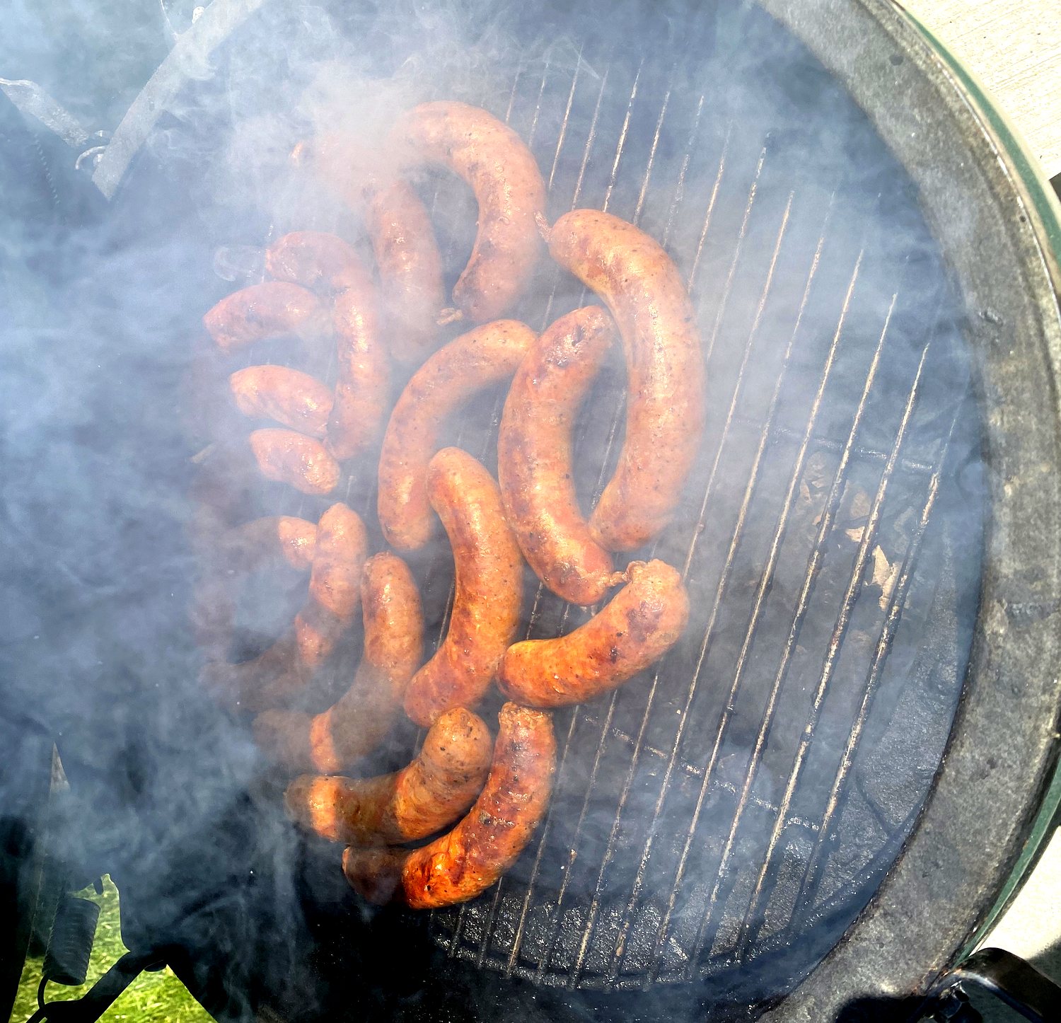 Kolbász links smoking low and slow, wreathed in wood smoke